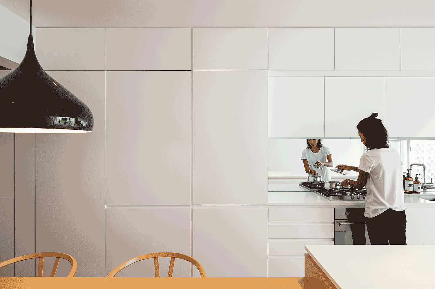 Black accents make a big impression in this all white kitchen area