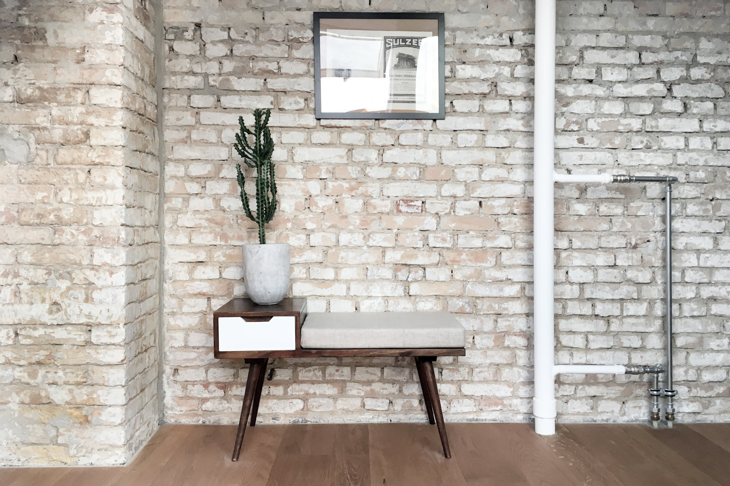 Brick wall backdrop in the apartment is preserved and enhanced to add texture to the interior