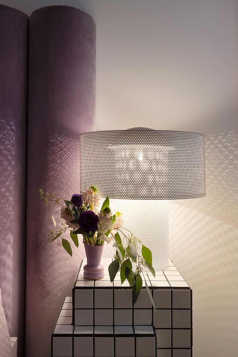 Chic nightstand that looks like a rubik's cube sits next to the bed