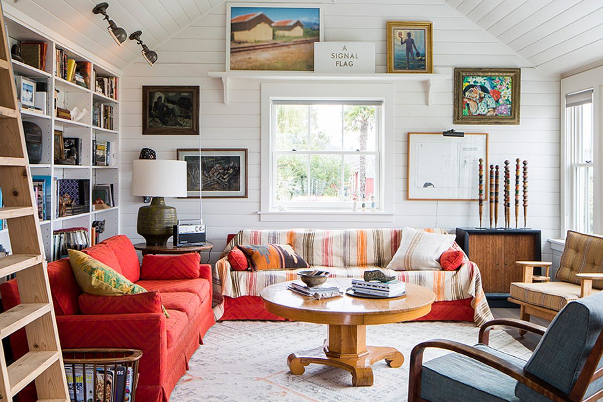 Combining colorful couches and lovely pattern with curated artwork inside living room of coastal home