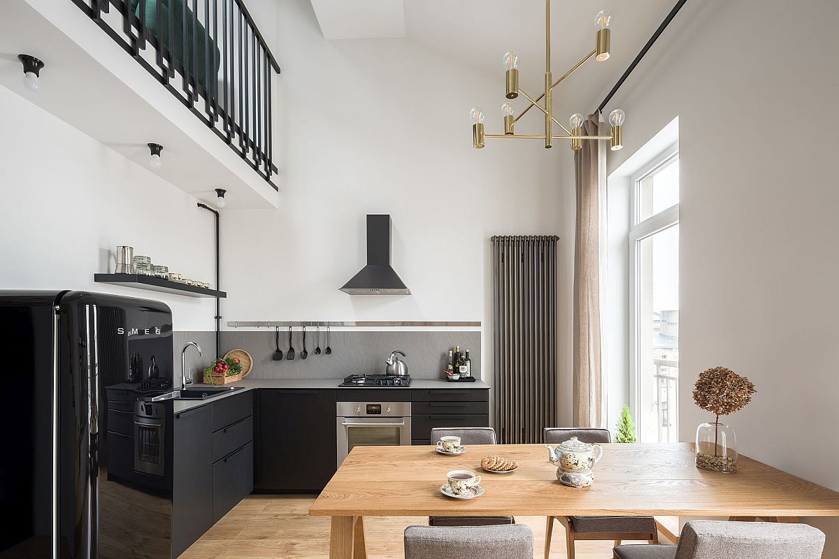 Double-height-dining-area-of-the-house-with-kitchen-in-black-next-to-it-49018