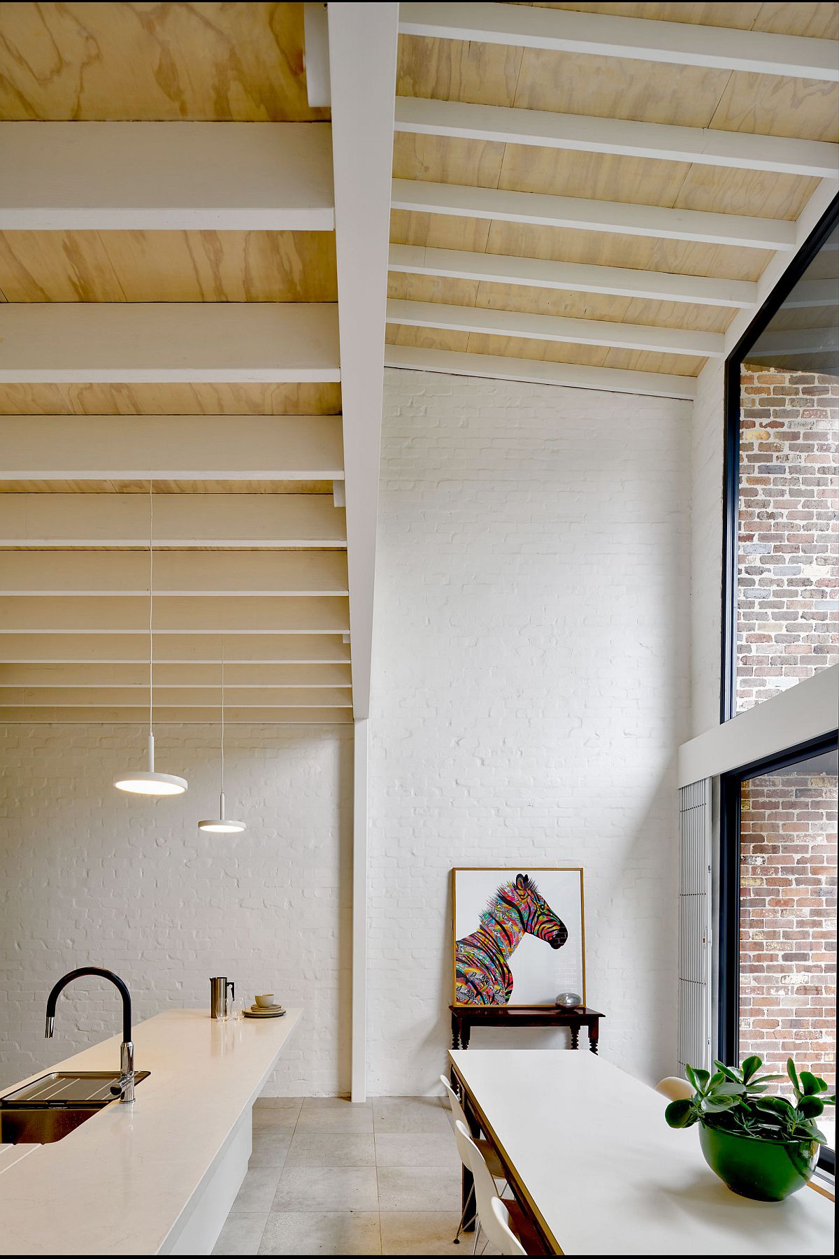 Double-height kitchen and dining area of the house with ample natural light and a modern-classic appeal