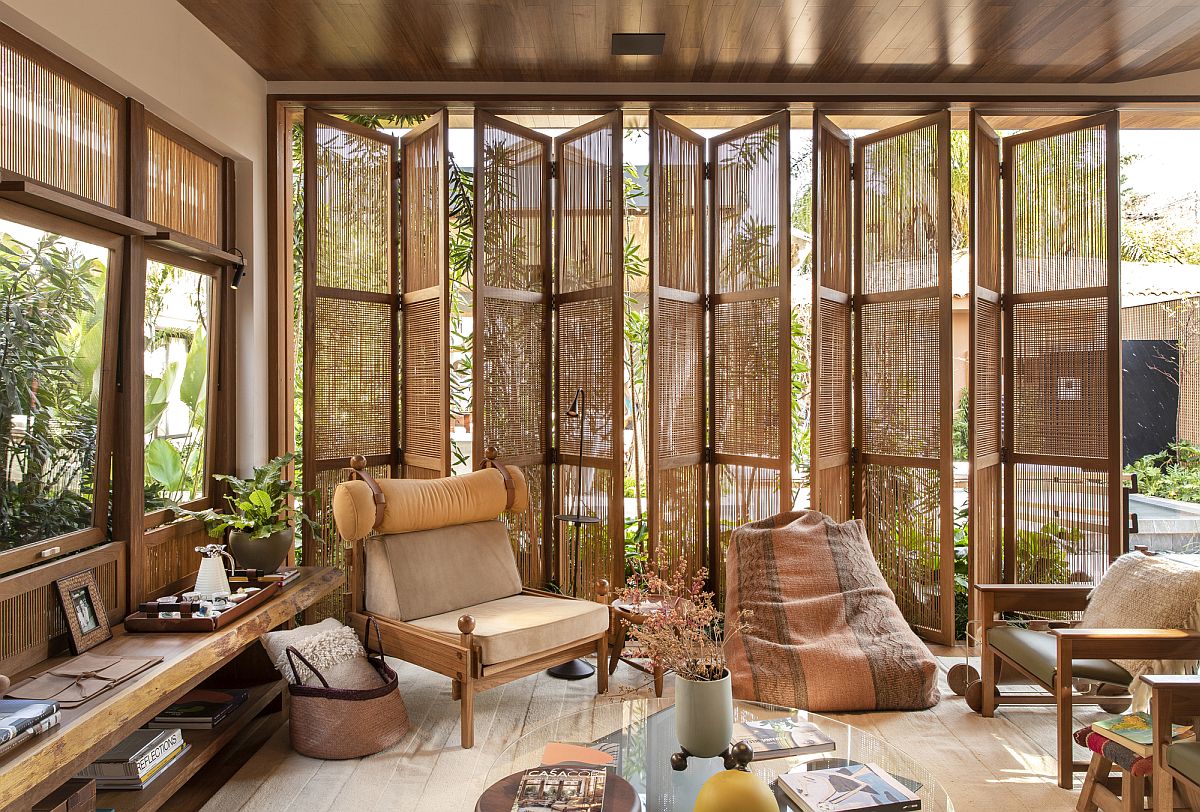 French accordion doors handmade with treenails connect this family room with the garden outside