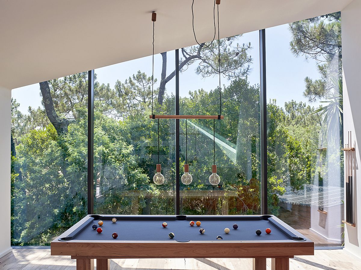 Game room on the upper level with glass walls offers lovely views of the landscape outside