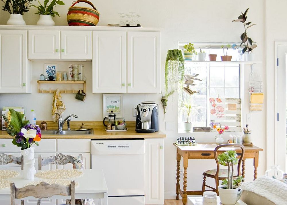 Indoor plants bring green tinge to this contemporary kitchen in white with a relaxed style