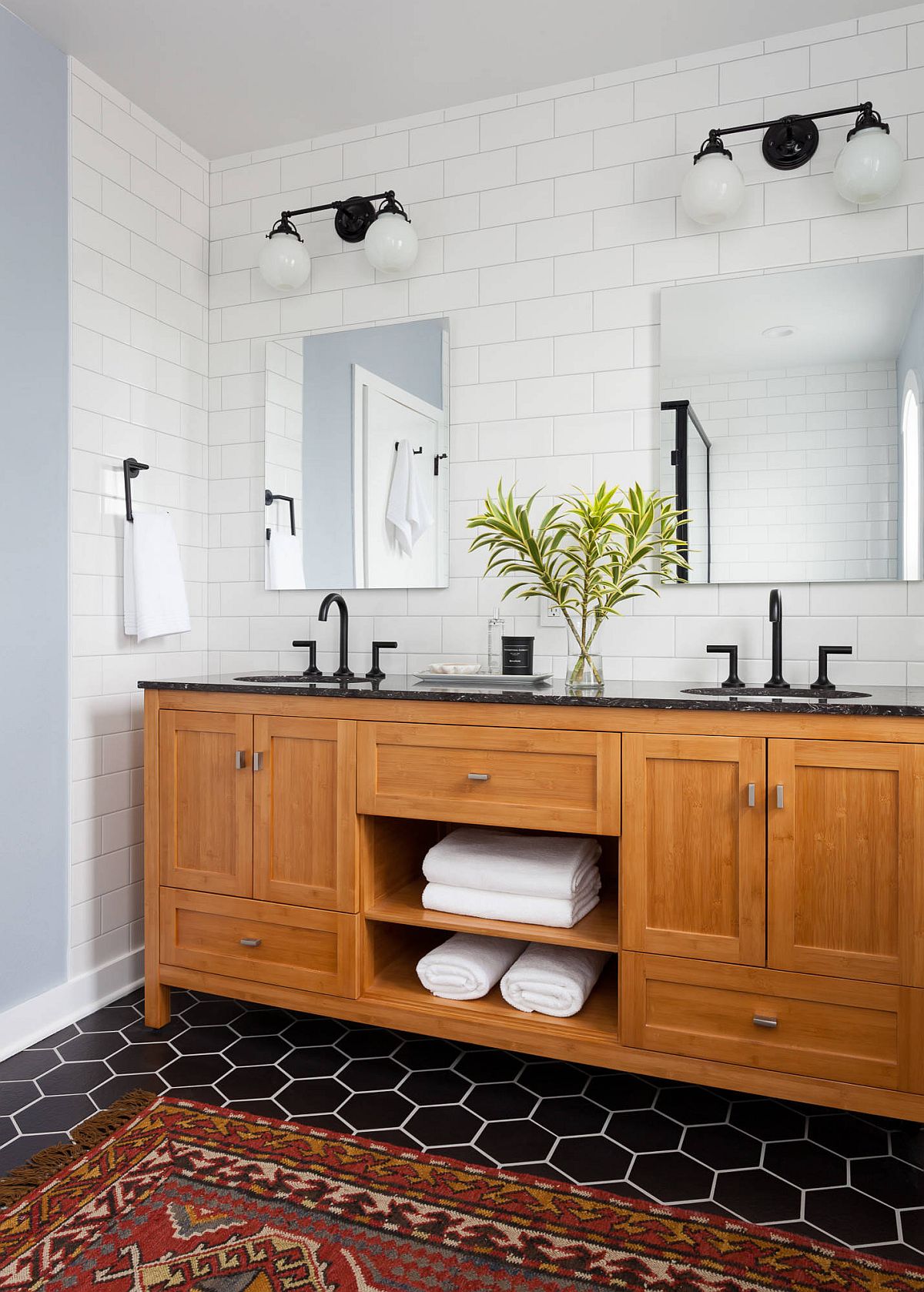 It is the floor that brings black to this black and white bathroom with a lovely wooden vanity