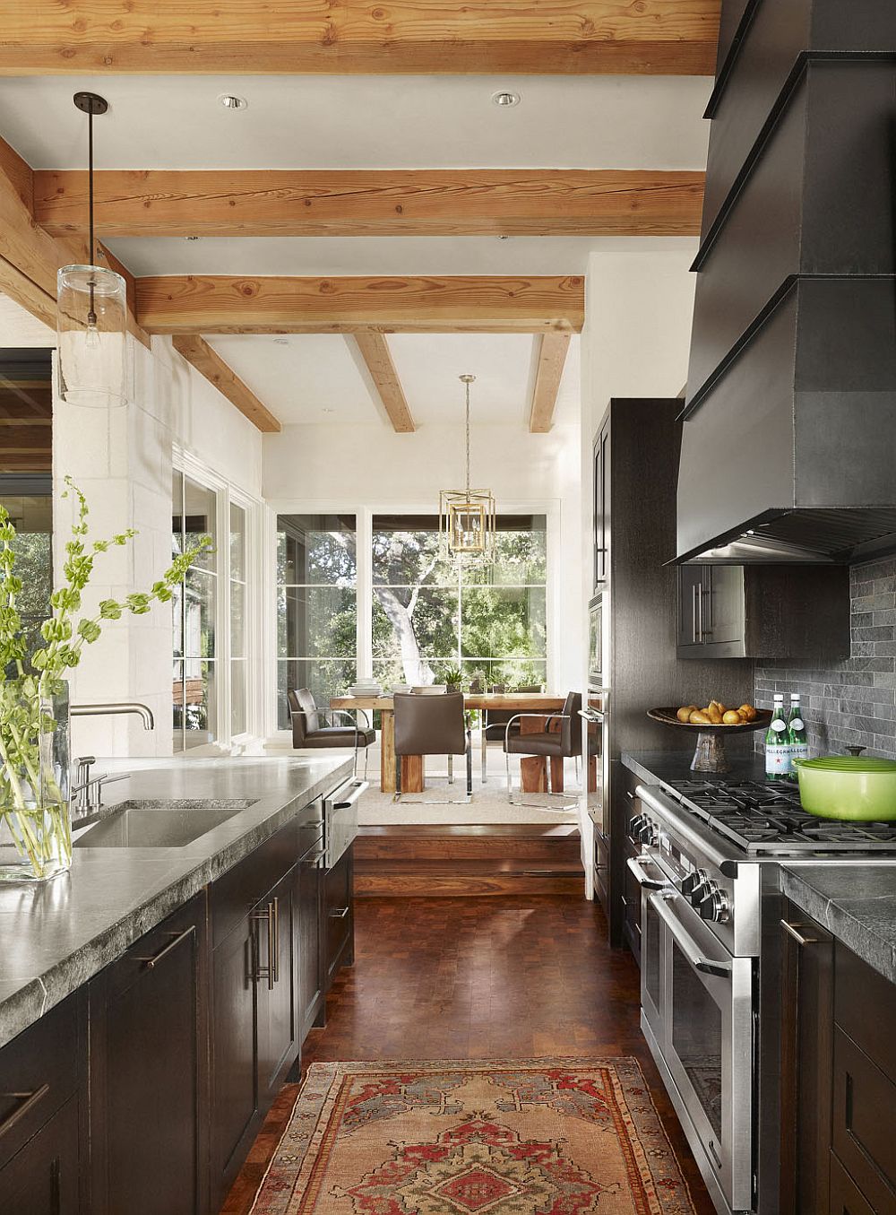 Kitchen and dining area of the Lake Austin House with an open design and exposed ceiling wood beams