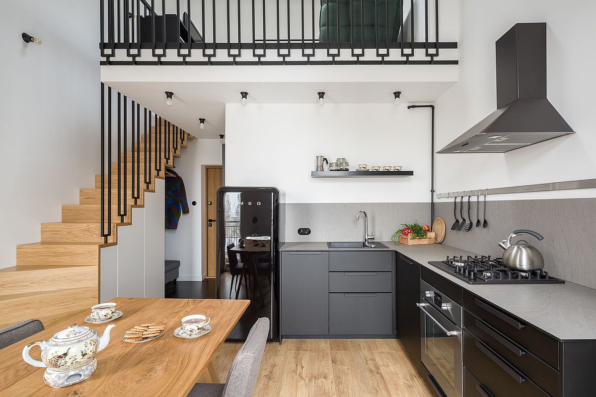 Kitchen-with-matte-black-finishes-and-gray-countertops-inside-the-small-Polish-apartment-24597
