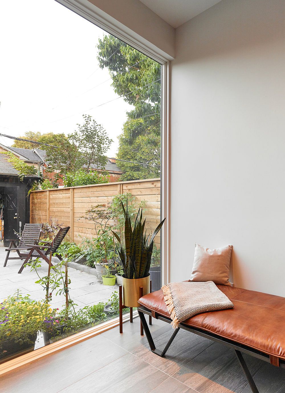 Large floor-to-ceiling glass wall connects the new interior with the backyard while bringing in ample natural light