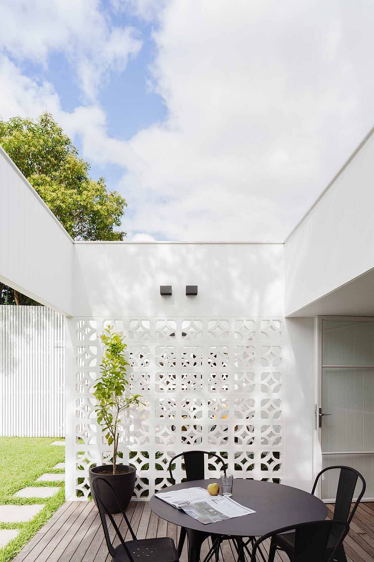 Large wooden decks with dining areas connect the interior with the rear yard