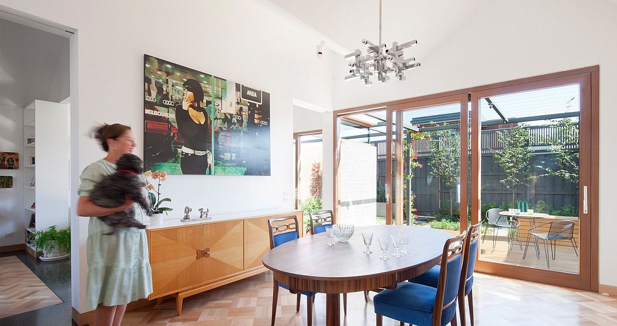 Lovely-dining-room-with-wooden-credenza-round-dining-table-and-blue-chairs-27383