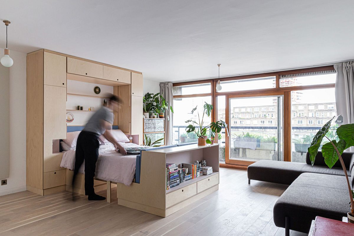 Lovely wooden bench wih built-in storage and a desk space acts as one supporting end for the fold-out bed