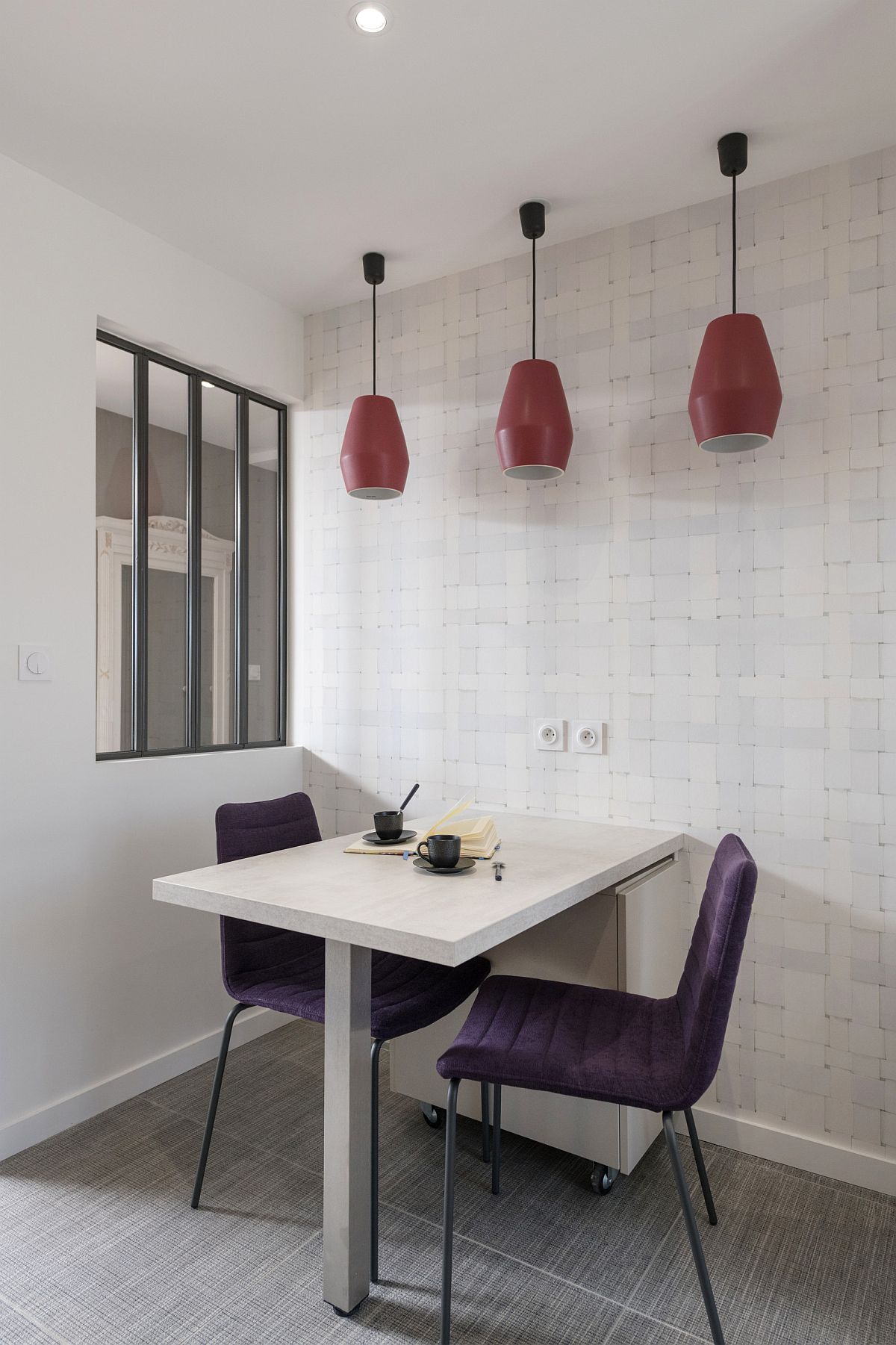 Red pendants add color and contrastto the minimal dining room in white