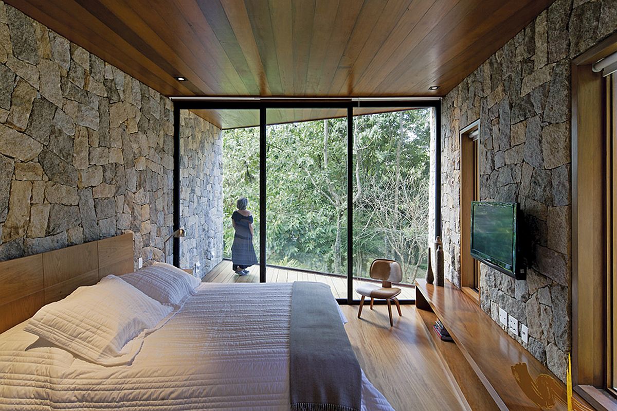 Relaxing retreat bedroom in wood and stone offers unabated views of the landscape