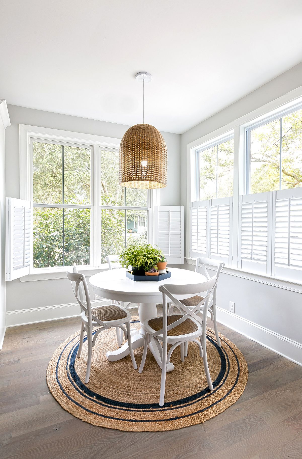 Rug and lighting fixture add to the coastal chic appeal of this small dining room