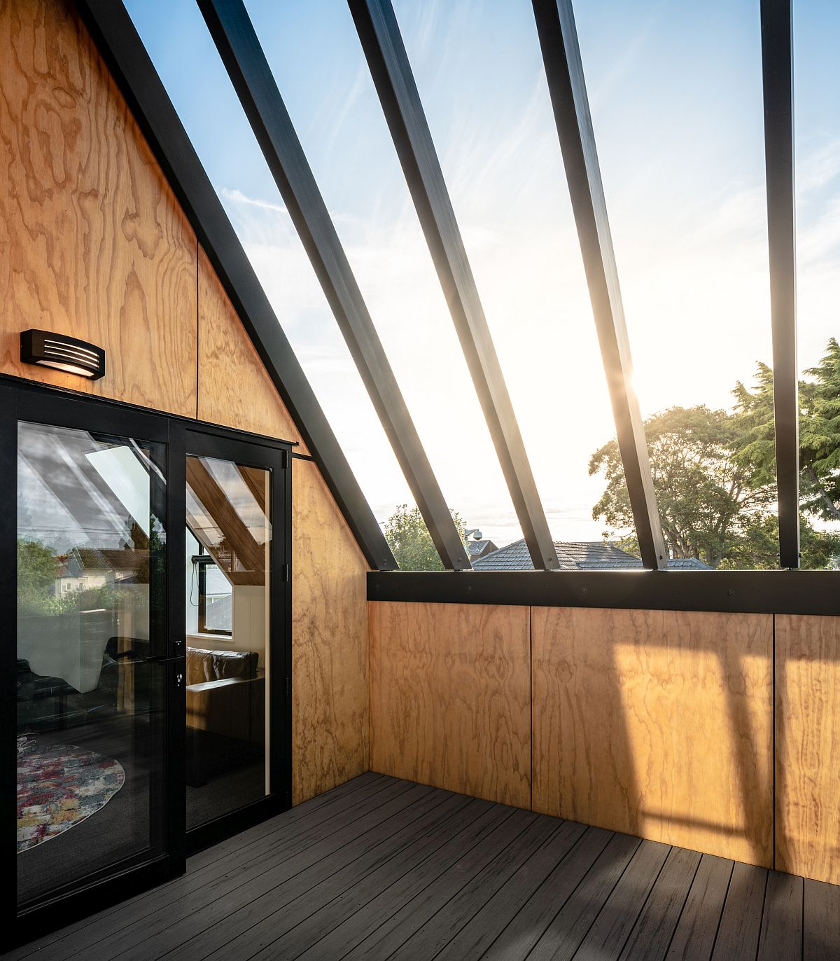 Sheltered deck of the house with ample natural light provides a getaway for those on the upper level