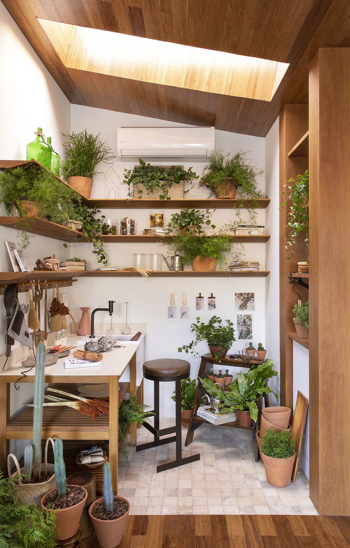 Skylight brings natural light into this small crafting room full of greenery