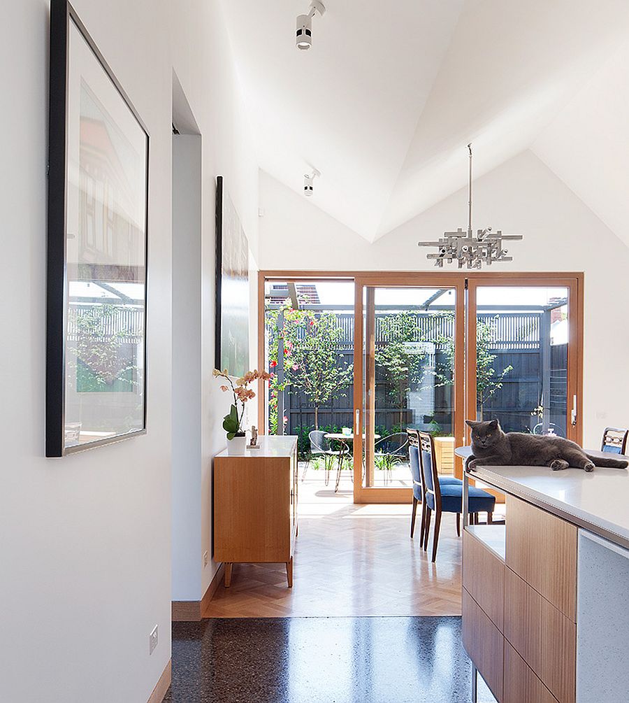 Sliding glass doors connect the dining area and the kitchen with the courtyard outside