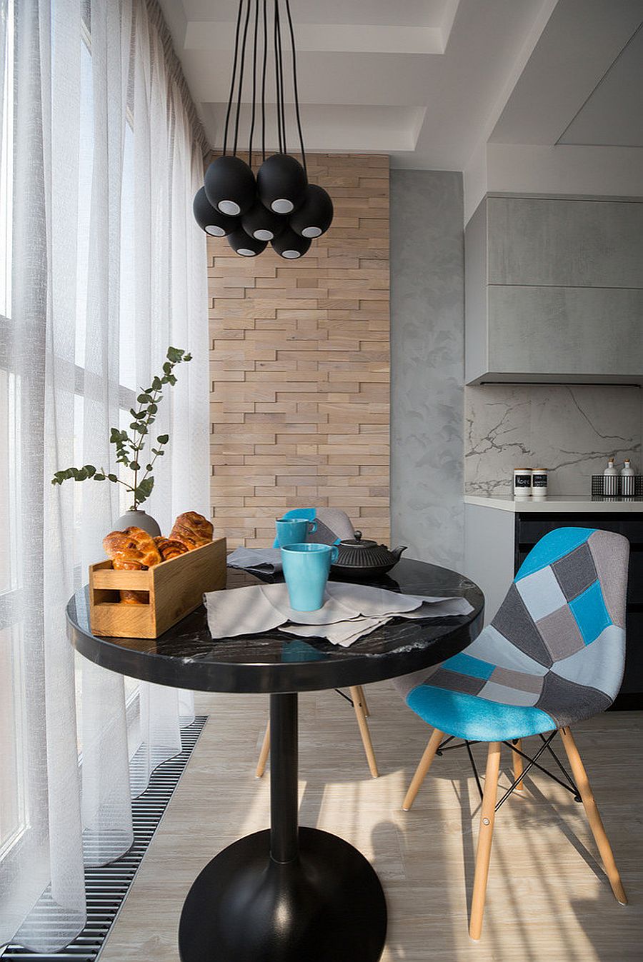 Small dark dining table coupled with black pendants in the tiny dining area