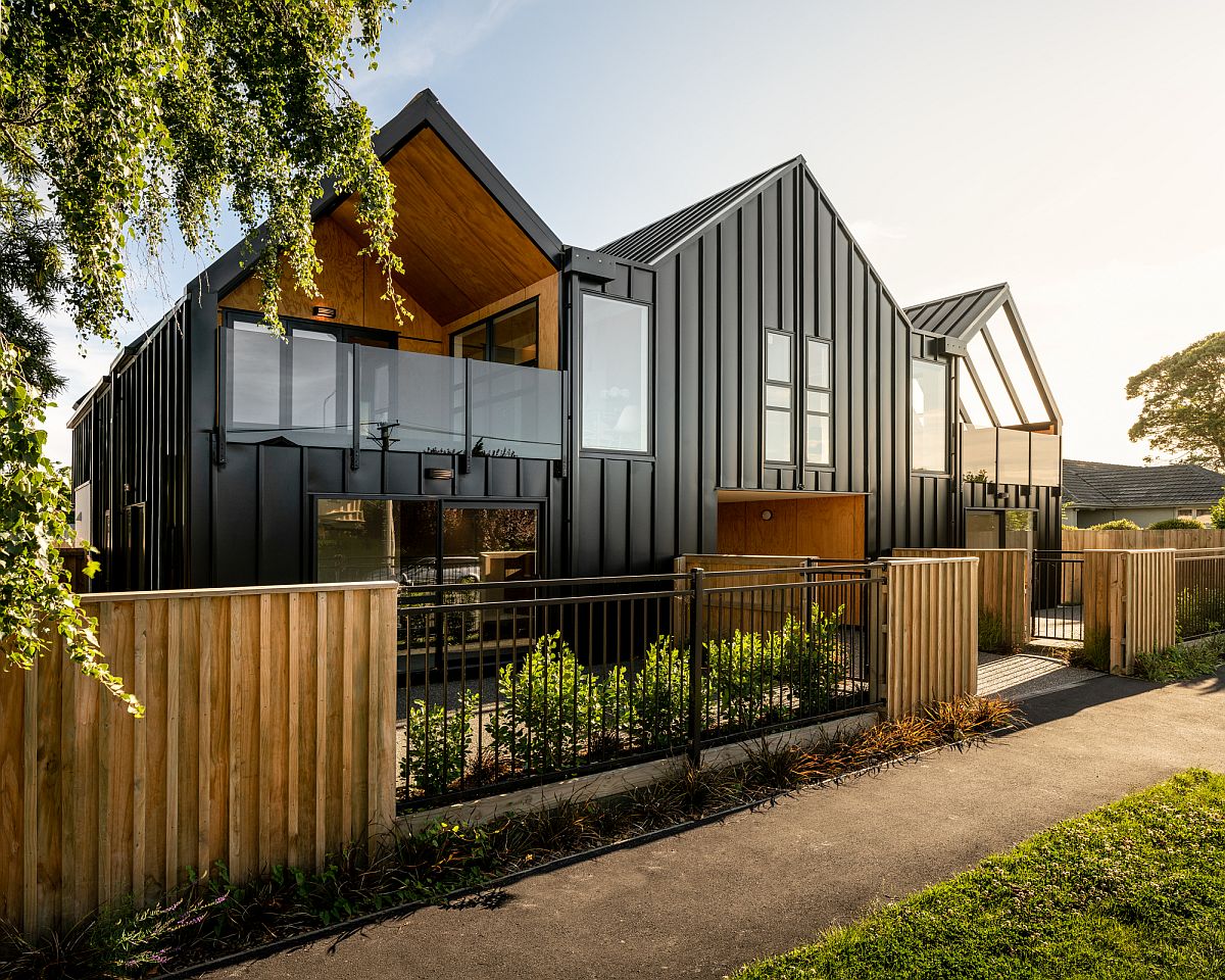 Street facade of the building clad in steel and glass with carport in the middle