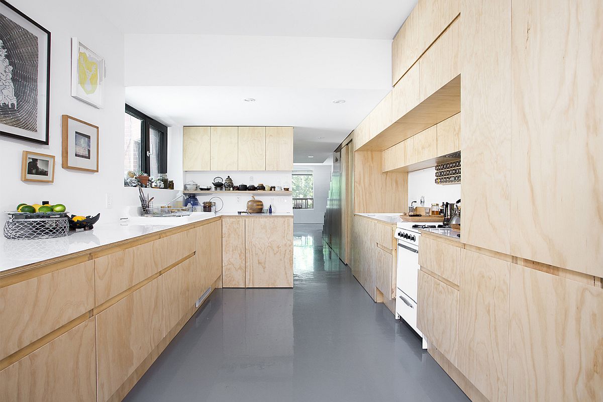 Wood and white kitchen of the revamped apartment unit with polished epoxy floor in gray