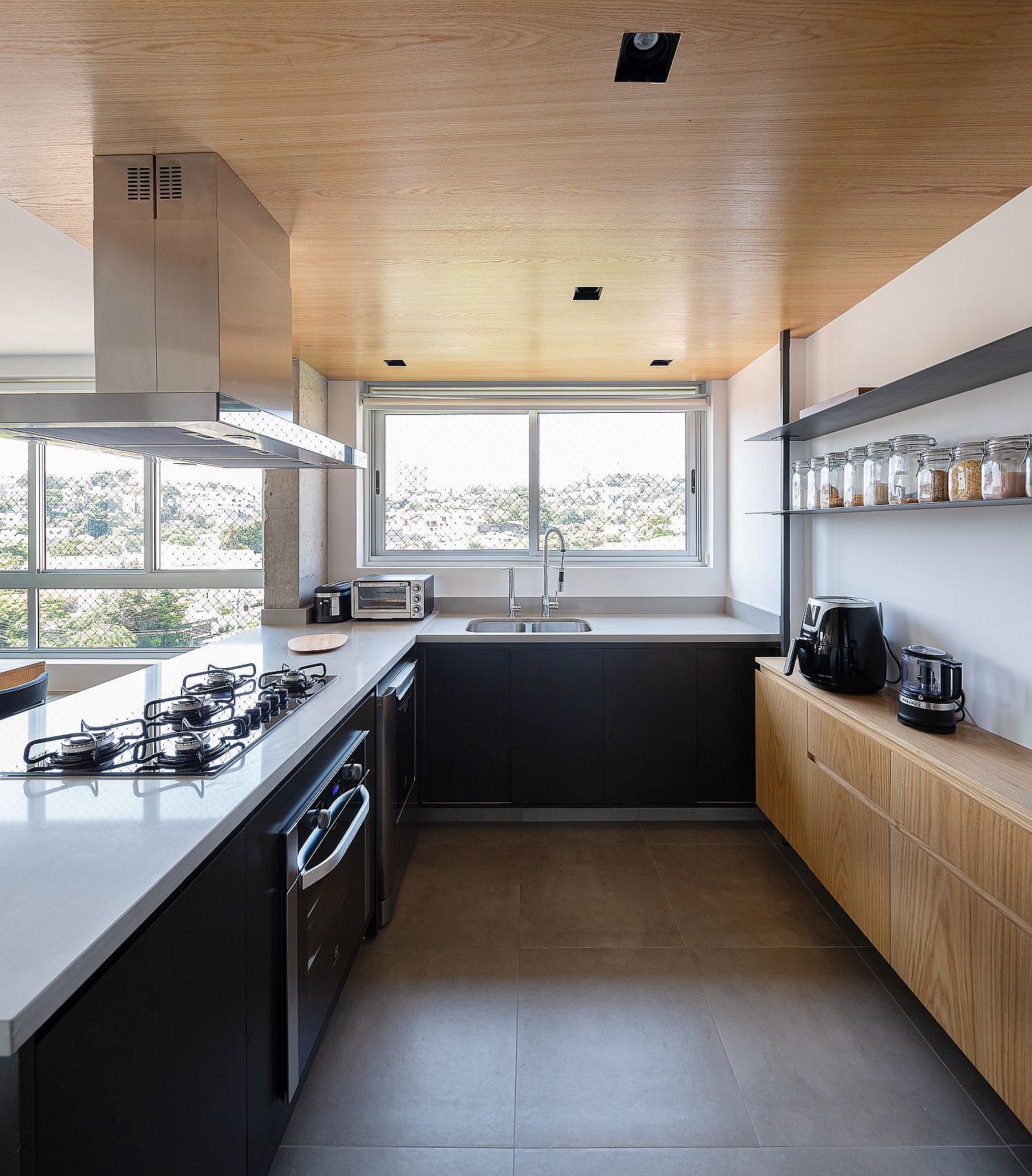 Wooden ceiling and shelves bring warmth to the spacious modern kitchen