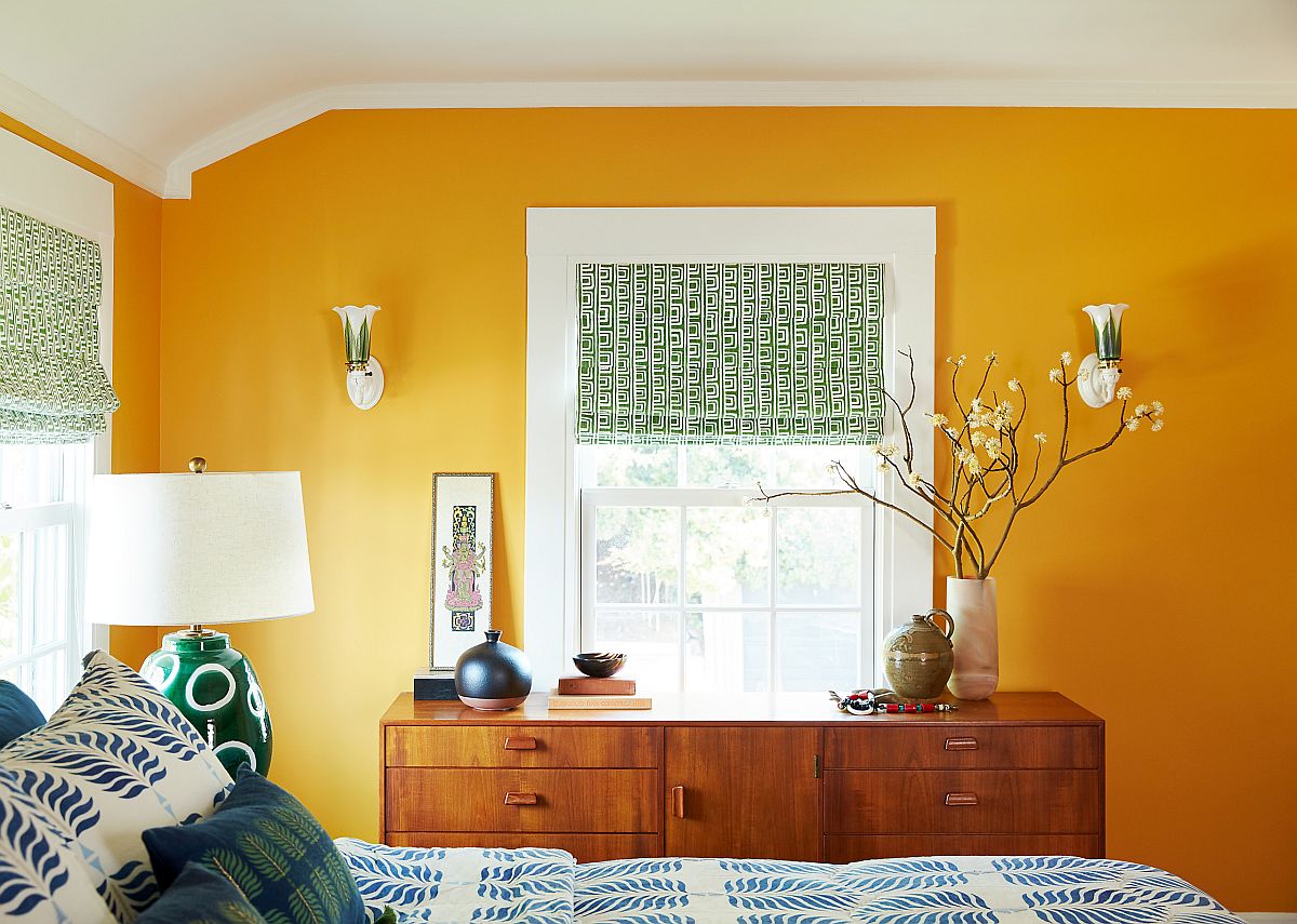 Dashing dark yellow accent wall in the eclectic modern bedroom makes a big visual impact