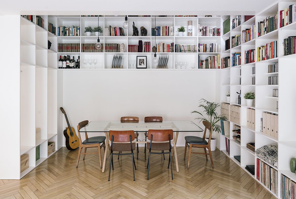 Double-height central living area of the house with bookshelves and glass table