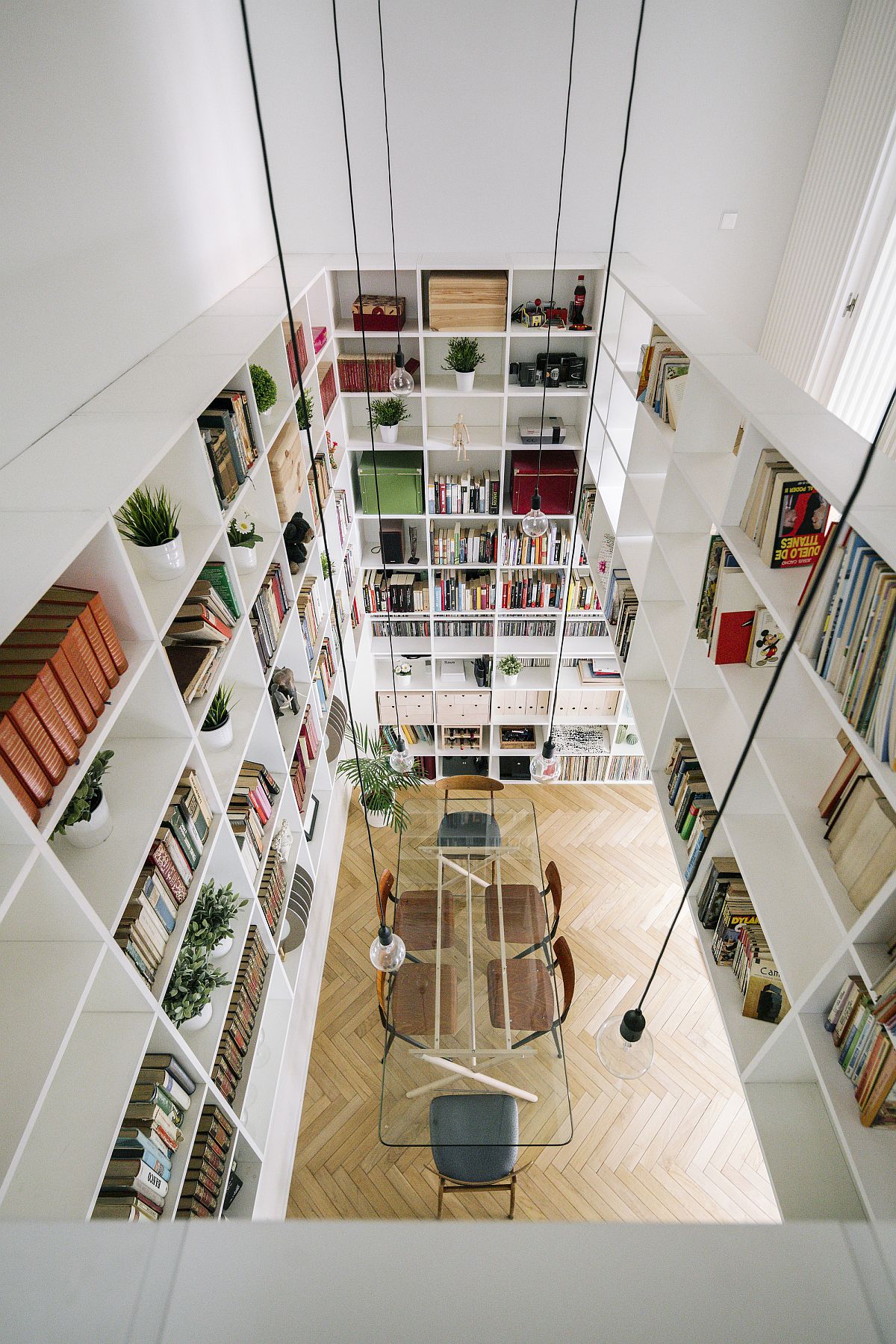 Double-height living area and dining room of the houe in white with lovely lighting