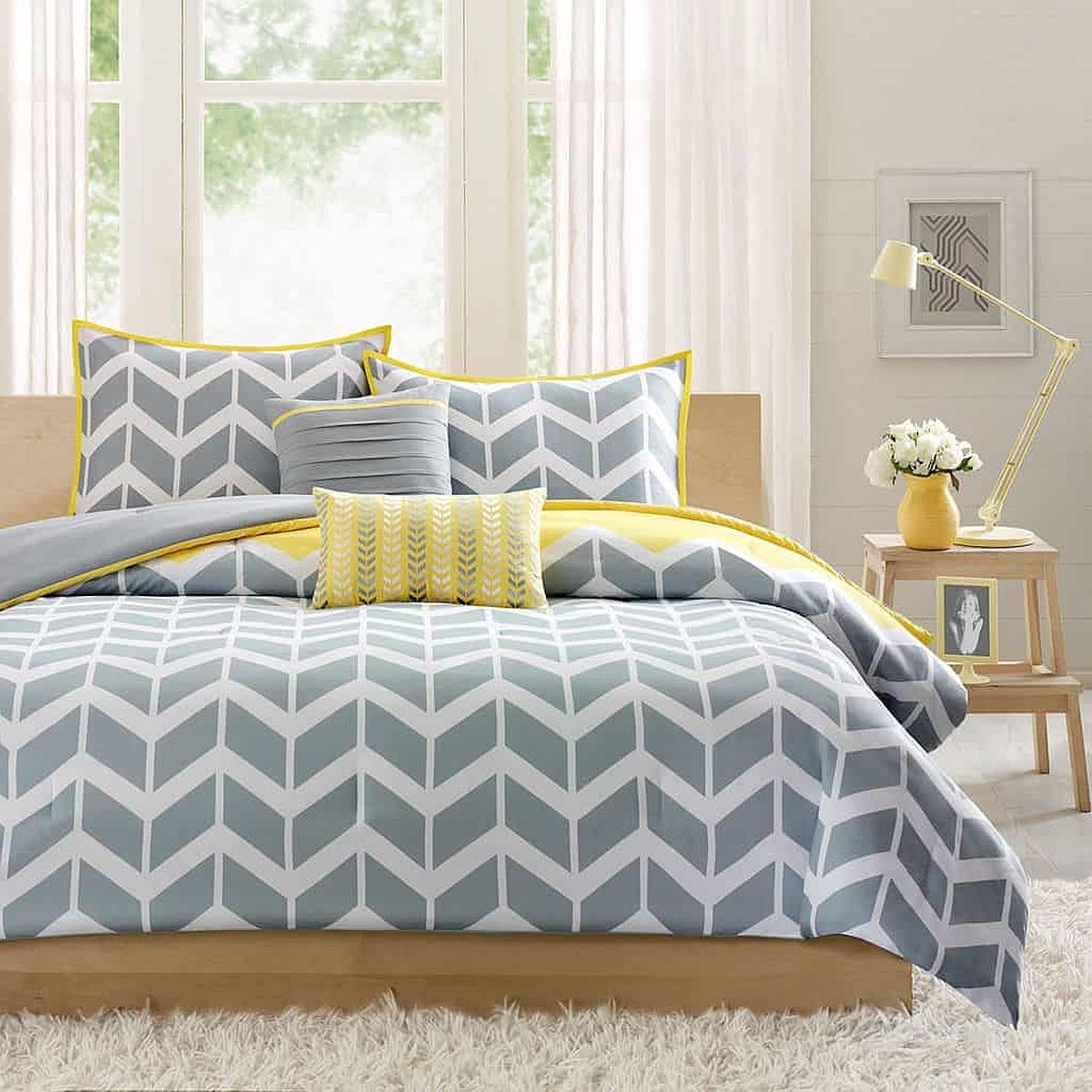 Fabulous gray and yellow bediing with chevron design brings both color and pattern to this bedroom in white