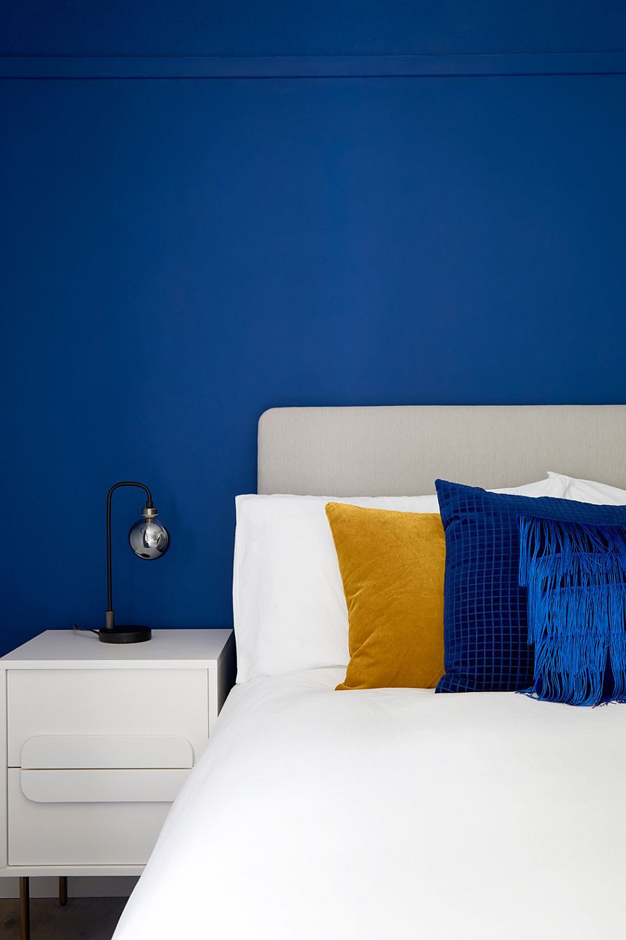 Modern and minimal bedside table lamp in a bedroom filled with plenty of blue