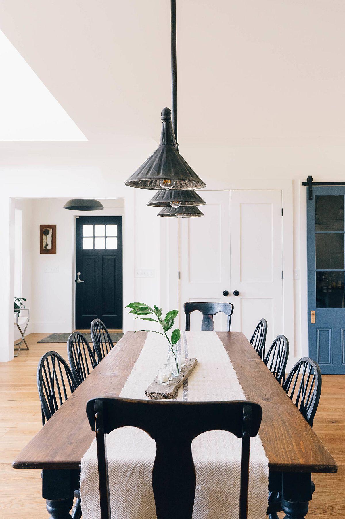 Pendant light and large wooden table brig industrial and farmhouse touches to this dining area