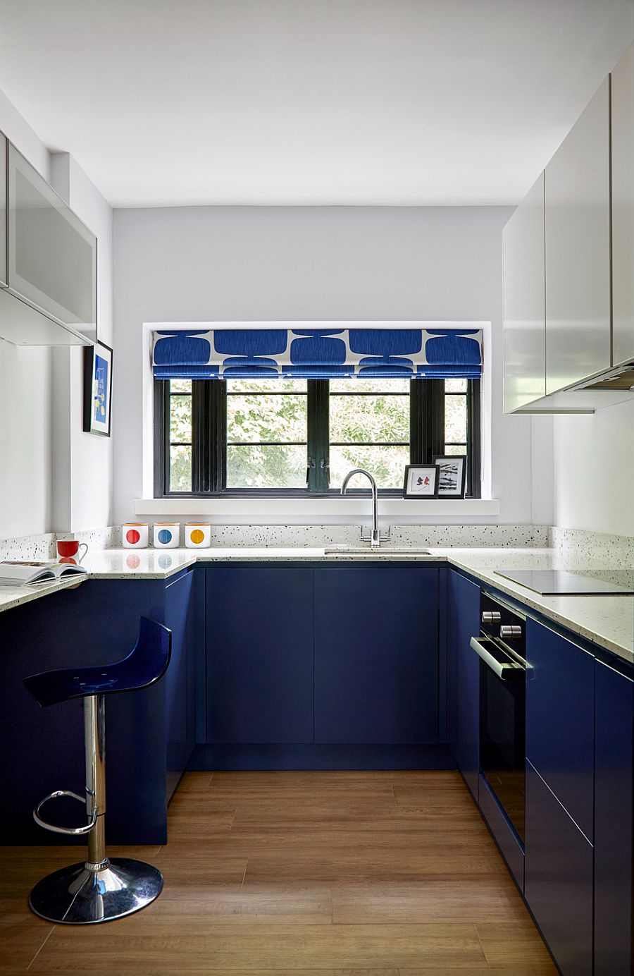 Polished contemporary kitchen in white and blue with blue cabinets below and white cabinets above