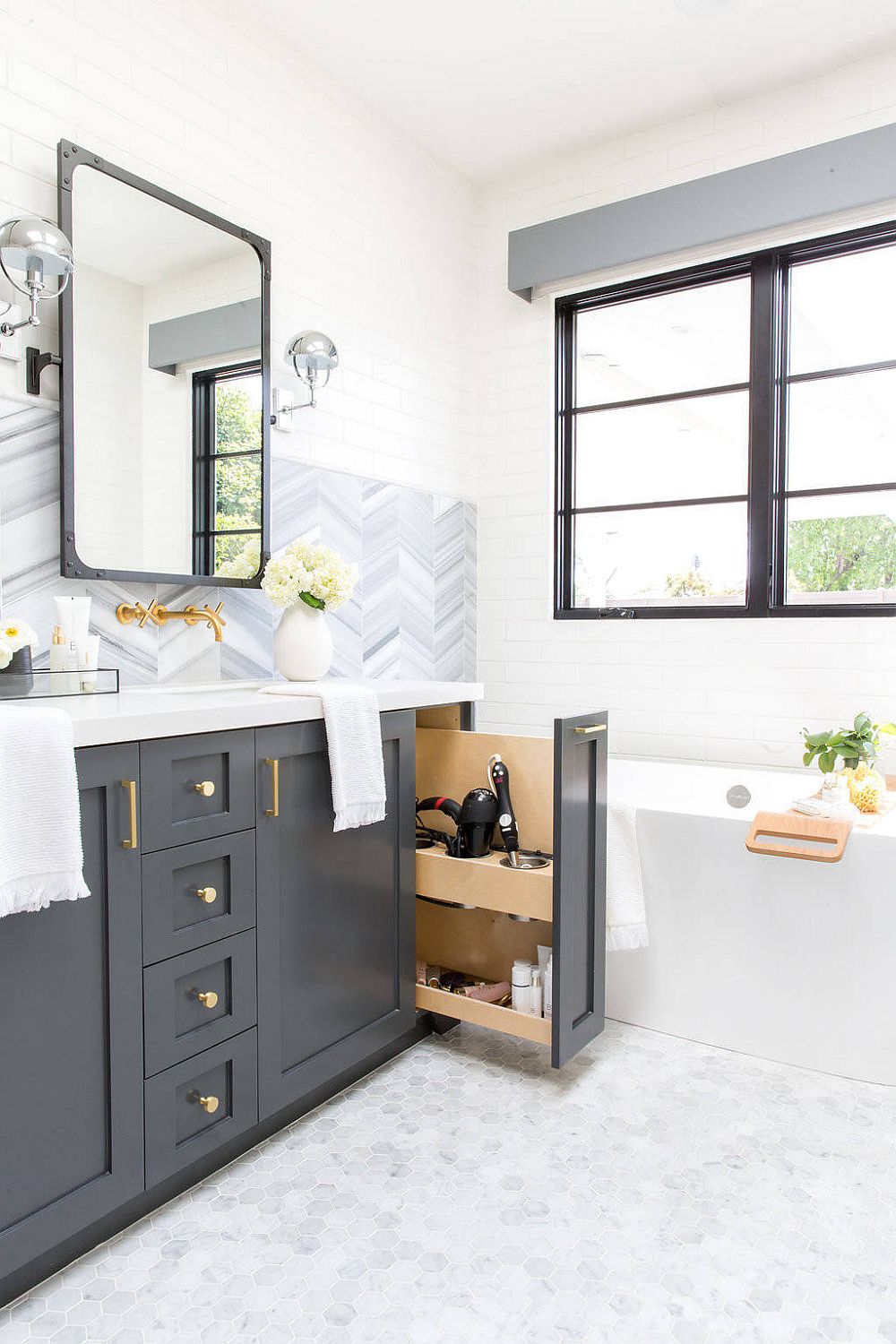 Polished industrial-farmhouse bathroom in white with gray cabinets and ample natural light