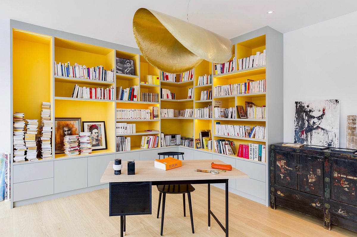 Stunning pendant in gold along with fabulous yellow shelves enliven this home office