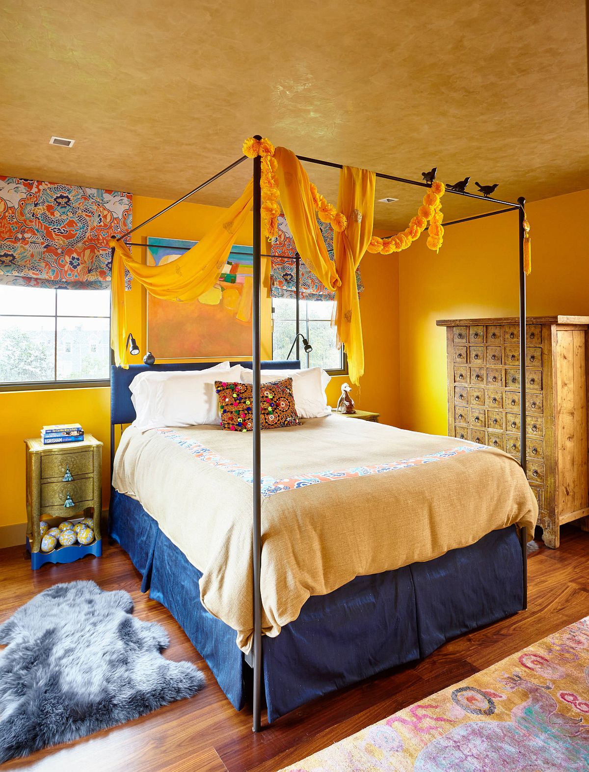 Textured yellow ceiling steals the show in this eclectic edroom with a bit of blue as well