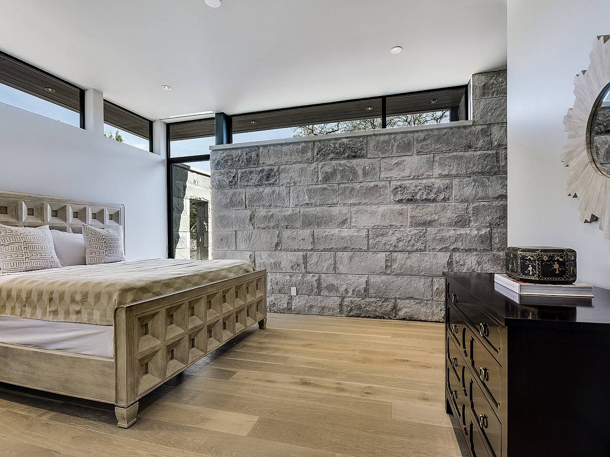 Amazing stone wall in the bedrooms ushers in gray in a space already filled with neutral colors