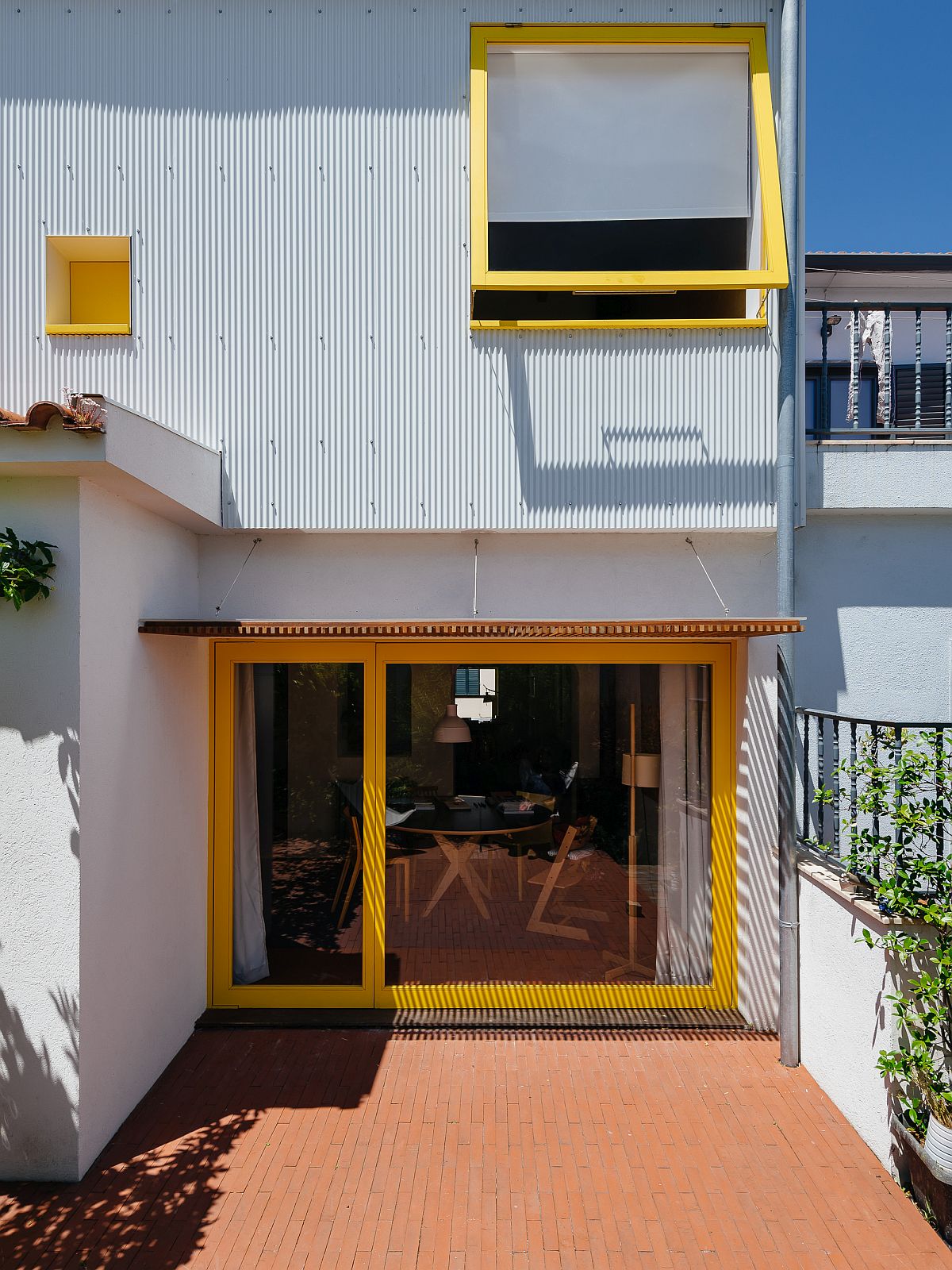 Backyard of the house is connected with the interior using sliding glass doors that have a bright yellow frame