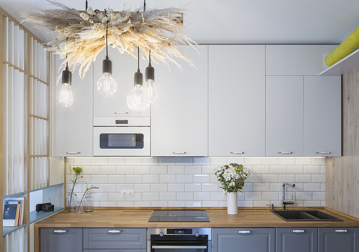 Beautiful Edison bulb lighting for the eat-in kitchen with wooden countertops grayish-blue cabinets