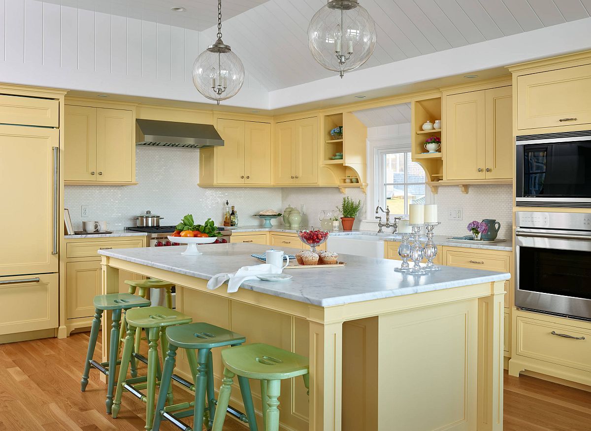 Breezy and cheerful beach style kitchen in light yellow where the bar stools bring in dark and pastel green