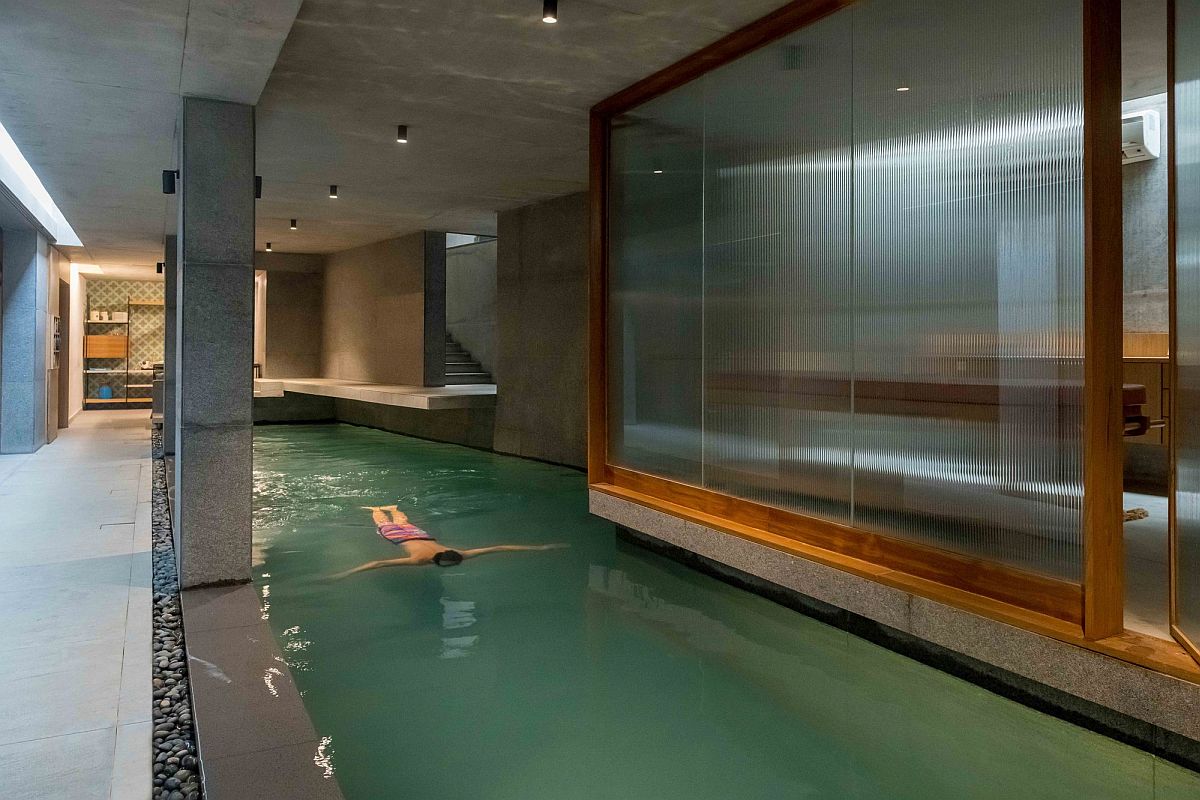 Concrete, granite stone and glass create the new underground level pool and spa at this Indian home