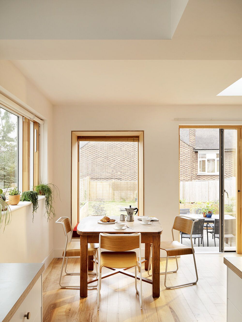 Custom windows and large glass doors bring ample natural light into the dining area and kitchen