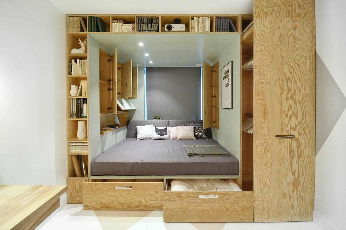 Custom wooden box inside the bedroom niche with ample storage and shelving units also houses the bed