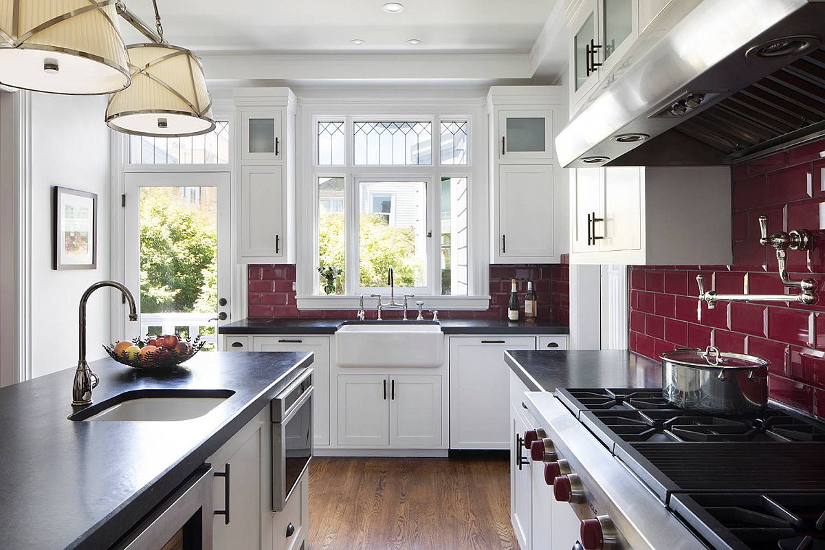 Dark maroon tiles shaping the backdrop make the biggest impression in this U-shaped kitchen