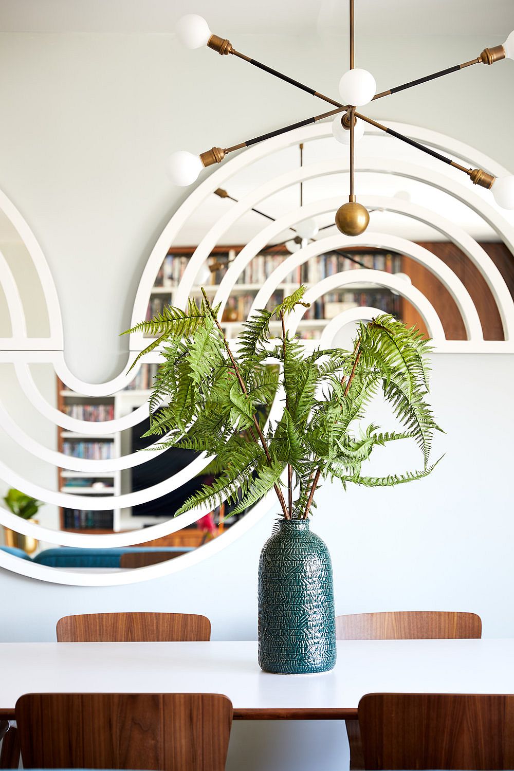 Dining area with lovely, innovative mirror in the backdrop that becomes a work of art