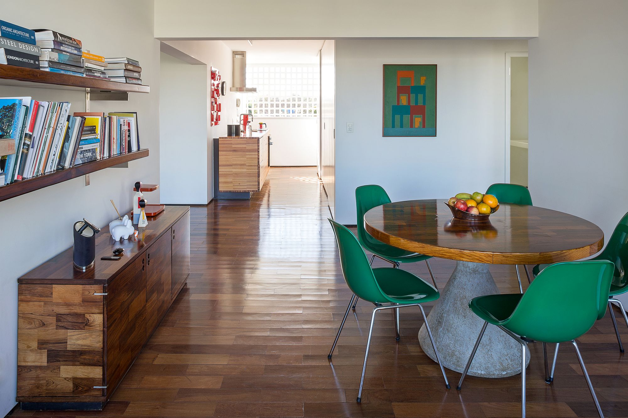 Dining table with concrete base, wooden top is surrounded by beautiful green chairs