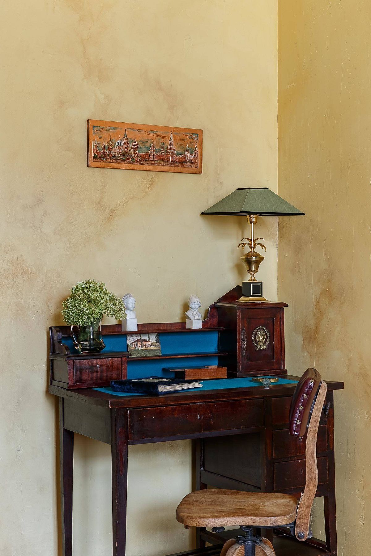 Eclectic home workspace in the corner with small freestanding desk and textured walls