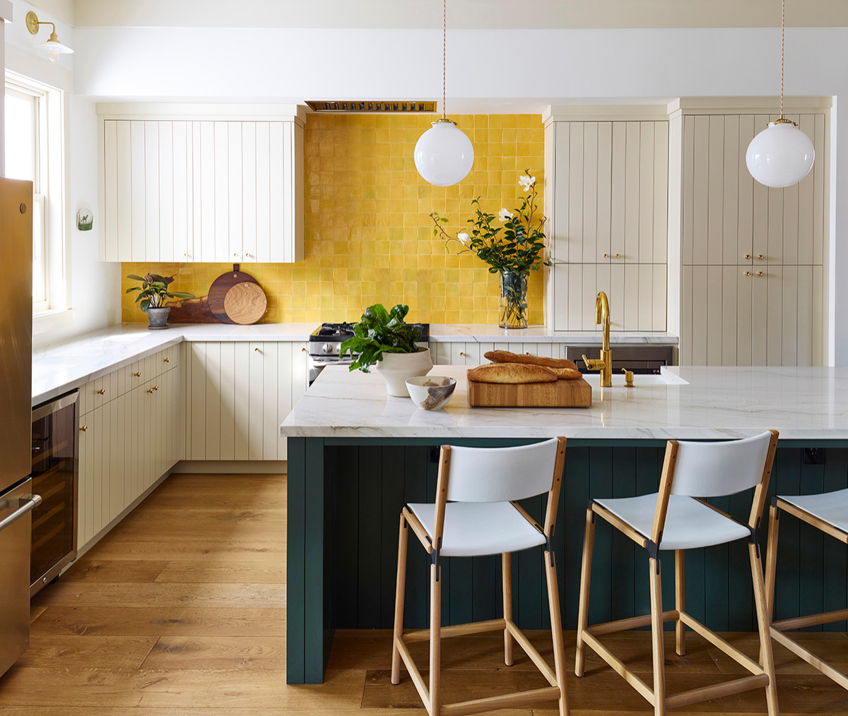 Handmade yellow backsplash in the kitchen coupled with deep and dark green island for a charismatic new look