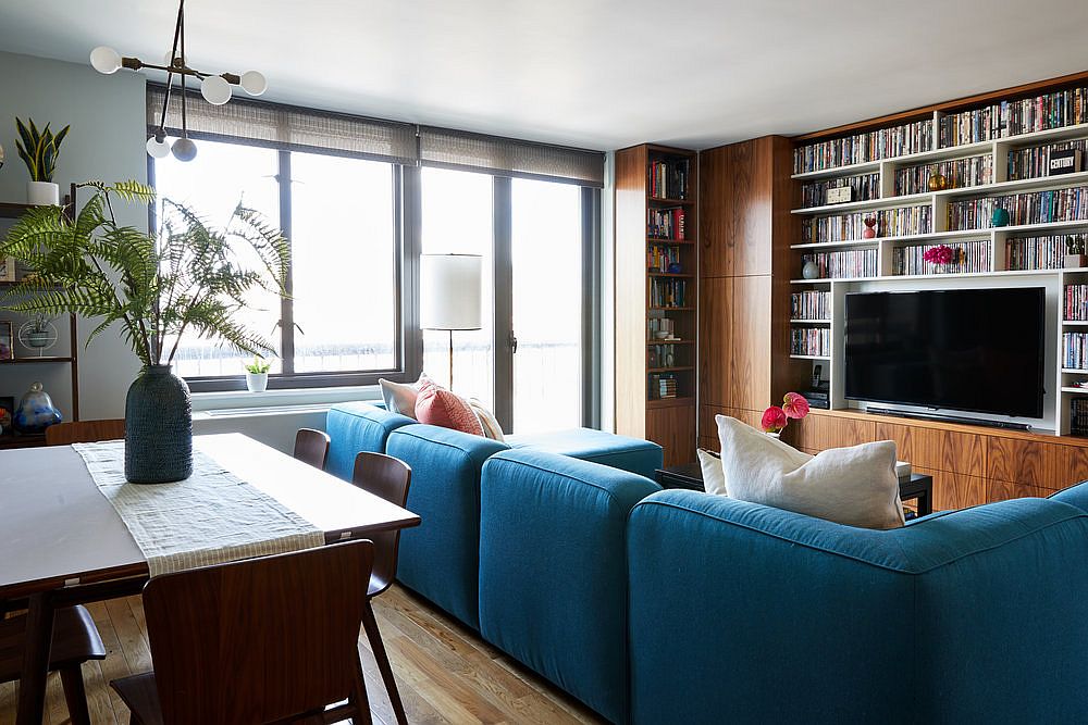 Large blue sectional separates the living area from the kitchen and dining space in open plan living