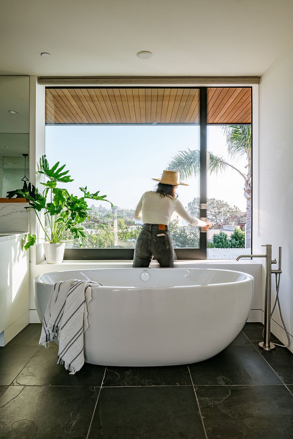 Large freeestanding bathtub in white is the focal point of the spacious modern bathroom